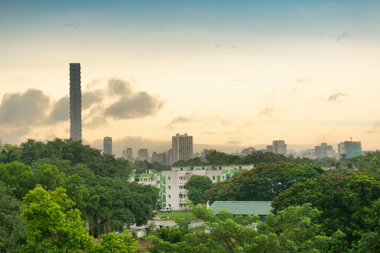 View of historical Kolkata city. Green trees in foreground covering buildings and skyline of Kolkata under morning sky in the horizon. Kolkata city photo.