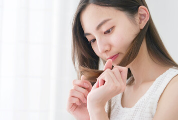 リビングで毛先を見る女性