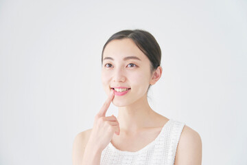 口元を指差す女性　白背景