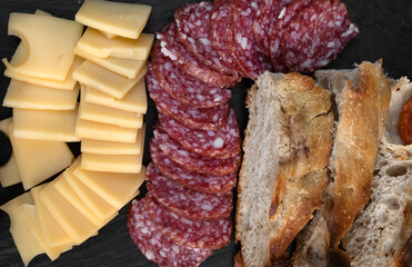 Antipasto. Top view of a dish with sliced salami, cheese and bread.