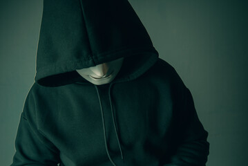A portrait of an anonymous hacker wearing a mask and a black hoodie sitting bear and scary. Hacking...