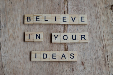 believe in your ideas text on wooden square, inspiration and motivation quotes