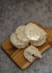 Krupuk or Kerupuk, Indonesia traditional crackers, served on wooden plate. Grey background. Selective Focus