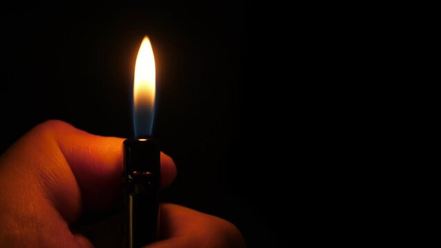Light cigarette lighter in the dark. Closeup