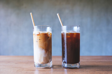 Two glasses of iced coffee with bio drinking straws on wooden table