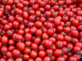 Delicious red farmers cherry tomatoes. Summer tray market agriculture farm full of organic vegetables. Full frame background close up selective focus. Top view, horizontal, vertical