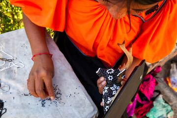 A local woman makes a souvenir with black and white pips. This is a prevalent form of art in Mexico.