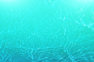 Defocus blurred transparent blue colored clear calm water surface texture with splashes and bubbles. Trendy abstract nature background. Water waves in sunlight with copy space. Blue watercolor shining