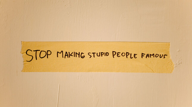 Naklejki word text of stop making stupid people famous written on duct tape isolated on dirty white wall. Wisdom Quotes Lifestyle quotes. Inspirational quotes.