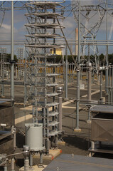 Electricity generating power plant showing high voltage insulators and a transmission tower.
