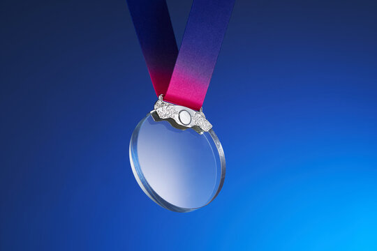 transparent silver crystal medal against blue background