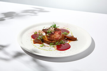 Baked camembert in parma ham on brioche with berry jam. Elegant food - hot appetizer of camembert and ham in summer menu. Cheese appetizer in fine dining. Summer menu.
