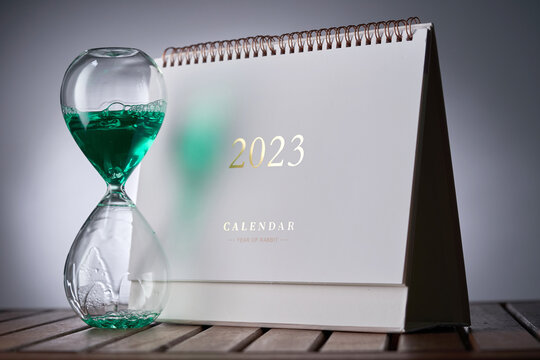 Hour glass and calendar concept for time slipping away ,welcome year 2023