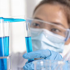 Scientists are carrying blue chemical test tubes to prepare for the determination of chemical composition and biological mass in a scientific laboratory, Scientists and research in the lab Concept.