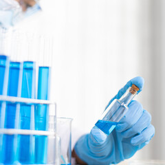 Scientists are carrying blue chemical test tubes to prepare for the determination of chemical composition and biological mass in a scientific laboratory, Scientists and research in the lab Concept.