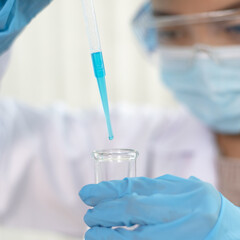 Scientists are carrying blue chemical test tubes to prepare for the determination of chemical...