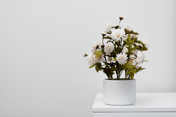 A pot of flower on table on white background with copy space.