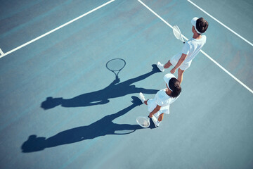Sport, fitness and tennis player team discussion of game strategy while walking together on a tennis court from above. Professional, athletic and competitive man and woman planning and training - obrazy, fototapety, plakaty