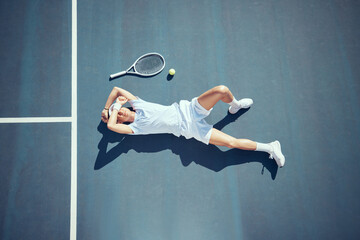 Tired tennis sports loser man on floor with racket, ball and court in summer sun from above. Relax...