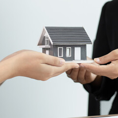 Sales manager or salesperson holds a demo house and has a home purchase contract with keys to...