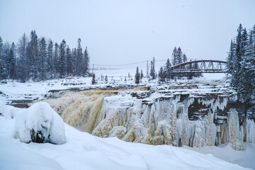 Fototapeta na wymiar View on the frozen waterfall of Chute-Aux-Galets on a snowy winter day near Saguenay, Quebec (Canada)