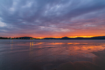 Obraz premium Colourful cloud filled sunrise at the seaside