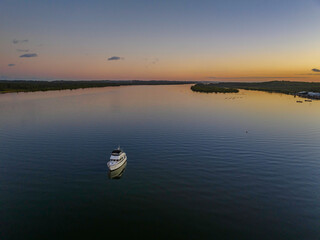 Sunset over the river with boat and reflections.