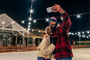Obraz na płótnie Canvas Couple take selfie ice skating