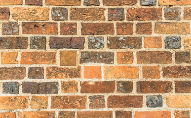 Brick wall in different shades of orange, brown and gray.