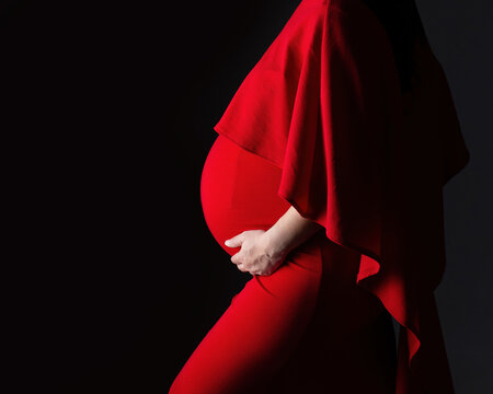 Dramatic maternity profile of a pregnant woman's belly from the side in 3rd trimester