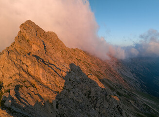 Sunrise in the Dolomites mountains with mist and clouds in the early morning. Fog rolling around the mountain peaks. 