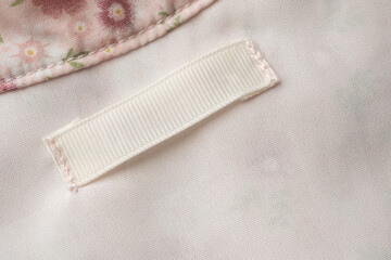 Blank laundry care clothes label on fabric texture background