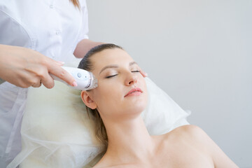 Obraz na płótnie Canvas View women's spa procedure. Electrical stimulation facial skin care. Microcurrent lifting face. Beauty spa procedure. Rejuvenation non-surgical treatment in the inner room