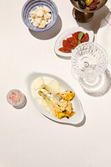 Italian antipasti - grilled artichoke with cheese and mayo sauce. Vegetable appetizer from artichoke and sauce on white table. Italian lunch with Roasted artichoke on sunny day. Trattoria menu.
