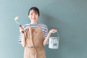 壁の塗装をする日本人女性（DIY）
