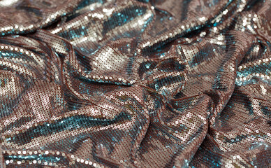 Fabric with sequins as a background. Glittery texture is the trend of the season. Sparkling color holographic blue, pink.
