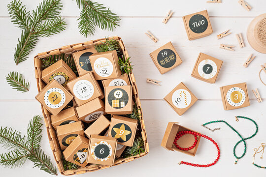 Filling in handmade advent calendar with jewellery. Gift boxes for Xmas. Eco friendly Christmas gifts diy concept