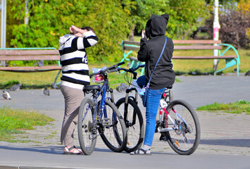 Two women preen up before cycling on an autumn day