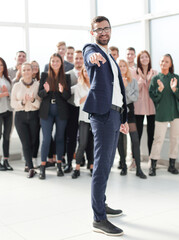 Fototapeta premium in full growth. smiling businessman pointing at you.