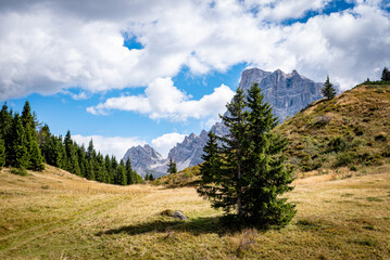 Obraz premium landscape with clouds over the mountains dolomiti monte Pelmo, with blue sky and green trees in Italy