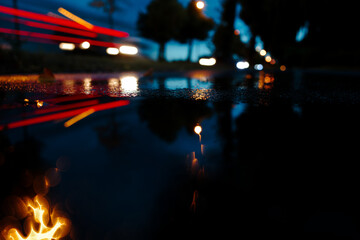 abstract and blurry view of stormy night at roadside with car taillights passing leaving light trails
