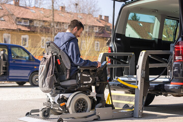 Accessible car with wheelchair lift ramp for person with disability.