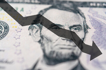 Arrow down on the background of dollar bill. The concept of inflation, depreciation of the dollar...