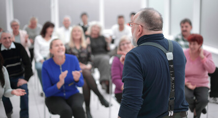 Mature caucasian man gives a speech in meeting in modern open office