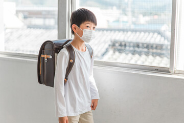 学校でマスクをつけている小学生の男の子
