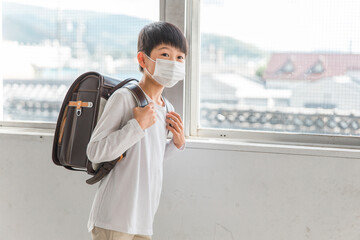 学校でマスクをつけている小学生の男の子
