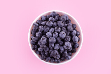 Top view of fresh ripe blueberries in bowl isolated on pink. Healthy, natural fruit. Vegan and vegetarian concept. Summer healthy food.