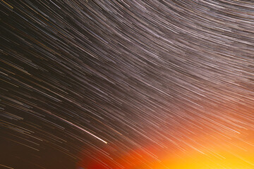 Meteors Trace On Night Dark Blue Sky Background. Spin Of Unusual Amazing Stars Effect In Sky. Abstract Bewitching Illusion Of Star Trails. Saturated Bright Yellow, Orange Colors.