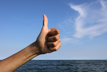 hand with thumb up pointing up ok sign all right and the sea