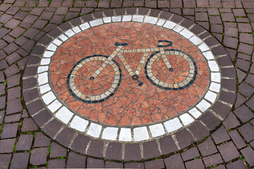 Round bicycle mosaic in a sidewalk of cobblestones. Bicycle mosaic on a sidewalk.